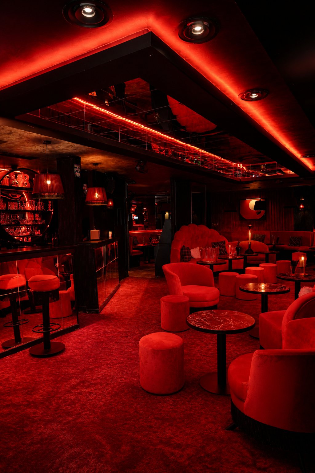 Fauteuils en velours rouge et tables à la bougie